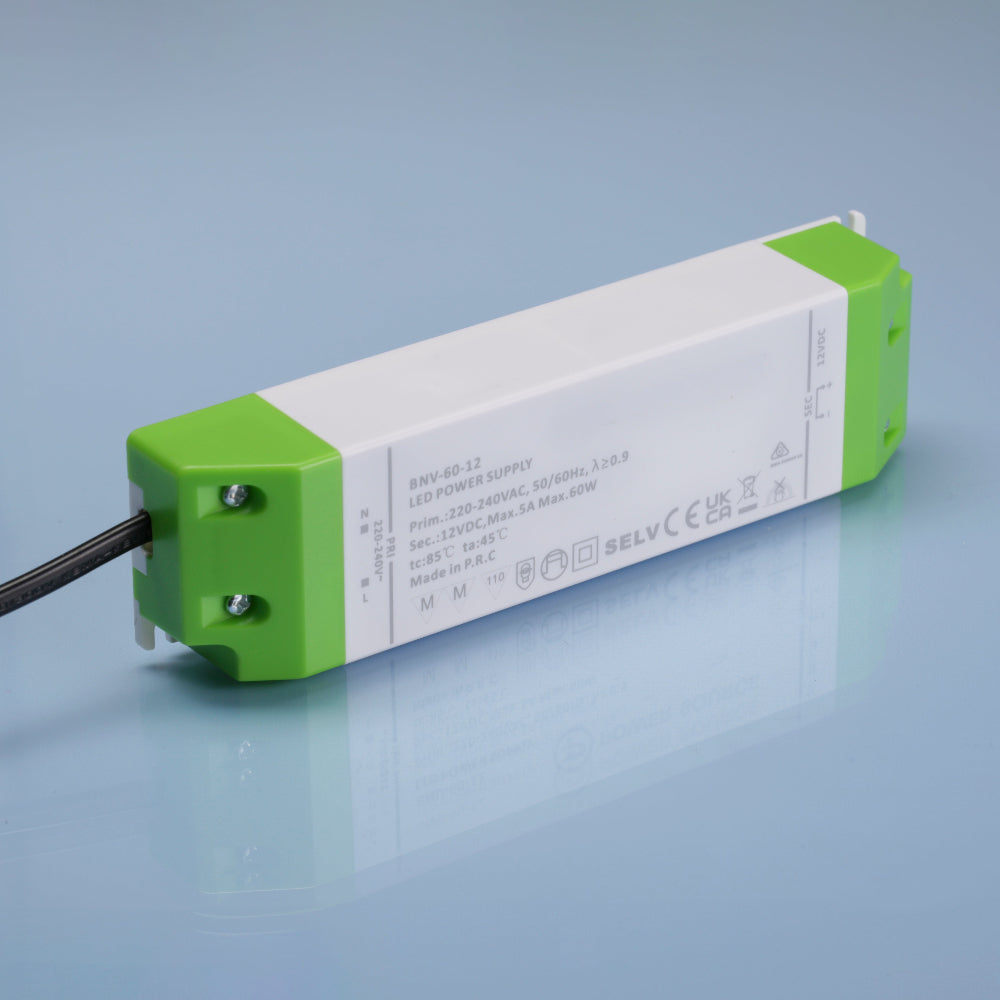 Rectangular electronic driver transformer power supply 60W component with green and white casing on a reflective surface